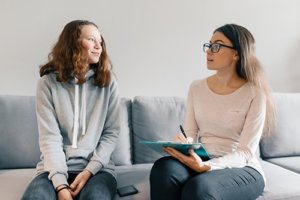 a counselor talks to a girl about types of eating disorder therapy
